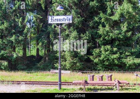 Old station lantern with place name sign and bench made of rusty guardrails. Stock Photo