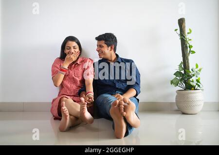 Young newlyweds sitting together and talking in their apartment. Stock Photo