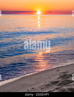 View from beach at sunset with ocean, colorful sky and sea Stock Photo