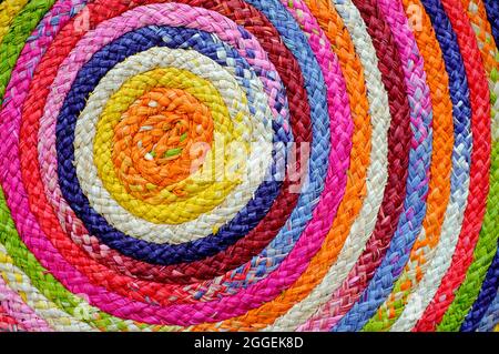 circular abstract pattern on a multi-coloured raffia style rug Stock Photo