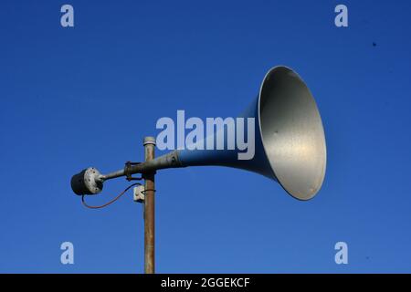 A blue and Silver Retro Megaphone with the backdrop of a clear blue sky Stock Photo