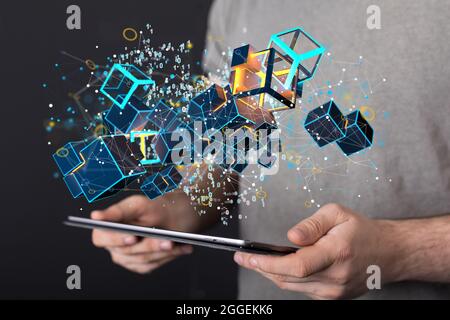 3D rendered cubes hovering over the man's hands holding a tablet. Stock Photo