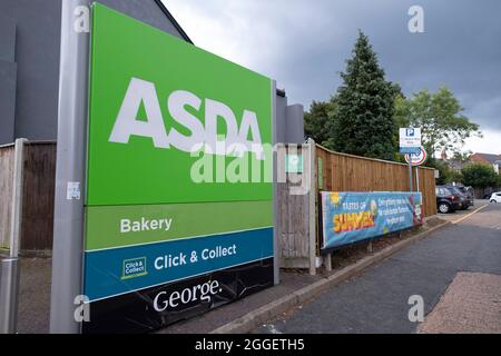 Asda supermarket chain sign in Kings Heath on 9th August 2021 in Birmingham, United Kingdom. Asda Stores Ltd. is a British supermarket retailer, headquartered in West Yorkshire. The company was founded in 1949 and was listed on the London Stock Exchange until 1999 when it was acquired by the American retail giant Walmart for £6.7 billion. Asda was the second-largest supermarket chain in Britain between 2003 and 2014 by market share, at which point it fell into third place. Since April 2019, it has regained its second-place position. Stock Photo