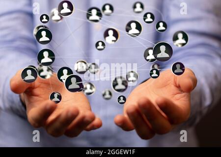 3D rendered profile icons hovering over the person's hands. Stock Photo