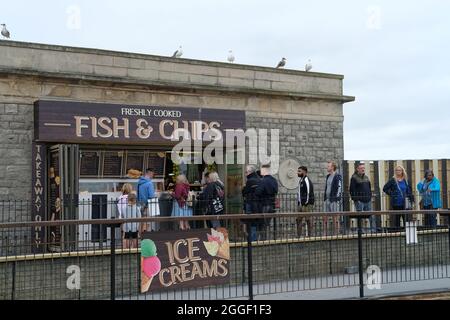 Holidaymakers queuing at a fish and chip shop in Weston Super Mare, UK. Stock Photo