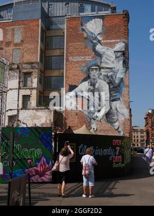 people photograph the  Glasgow 2014 Commonwealth Games Badminton mural by Australian artist Guido van Helten, Merchant City,Glasgow city centre, Scotl Stock Photo