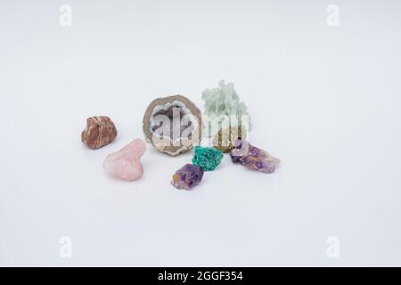 Colorful precious ornamental stones such as Amethyst, Rose Quartz, Chrysocolla on a white background. Selective Focus Stock Photo