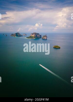 A speedboat travels to the tropical islands with tourists off the coast of Krabi, Thailand. Stock Photo