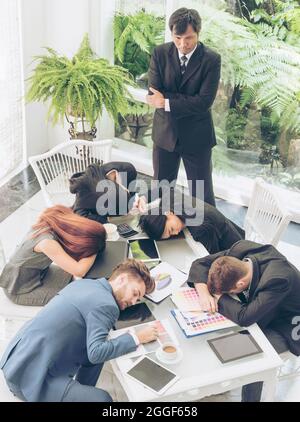 Worker lazy person sleep exhausted with tired meeting. Diversity group of business people sleeping in conference room after meeting. Executive boss an Stock Photo