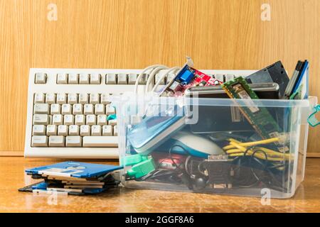 Arahal, Seville, Spain. August, 22, 2021. Computer keyboards and obsolete electronic and technological objects in a plastic box. Concept of technologi Stock Photo