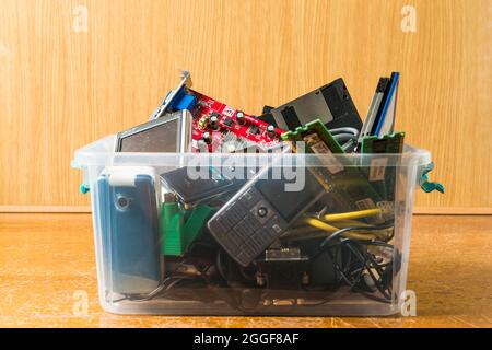 Arahal, Seville, Spain. August, 22, 2021. Obsolete electronic and technological objects in a plastic box. Concept of technological waste and its recyc Stock Photo