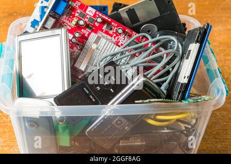 Arahal, Seville, Spain. August, 22, 2021. Obsolete electronic and technological objects in a plastic box. Concept of technological waste and its recyc Stock Photo