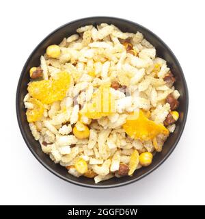 Close-Up of Crunchy Diet Mixture in a black Ceramic bowl made with Puffed Rice, Corn Flakes, and Curry leaves. Indian spicy snacks (Namkeen) Top  View Stock Photo