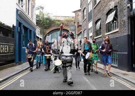 London, UK. 31st Aug 2021. Protestor pictured leading a band of drummers through Borough Market during Extinction RebellionÕs Stop The Harm protest on the ninth day of their Impossible Rebellion protests in London, United Kingdom on August 31, 2021. Kieran Riley/Pathos Credit: One Up Top Editorial Images/Alamy Live News