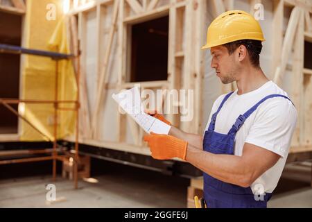 Male construction worker studying architectural building plan Stock Photo