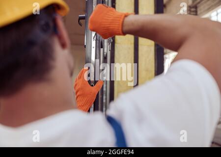 Male worker repairing door in building under construction Stock Photo