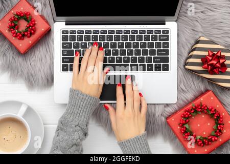 Womans hands with trendy red manicure typing on the keyboard Stock Photo