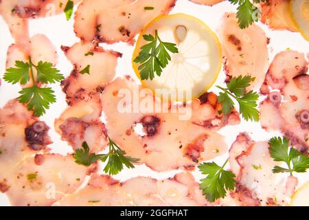 Presentation portion of octopus carpaccio co lemon and olive oil Stock Photo