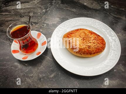 Famous Turkish Pastry /  Pogaca served with hot Turkish Tea / Cay. Bakery products are very famous in Turkish cuisine.  Pogaca and tea popular in brea Stock Photo