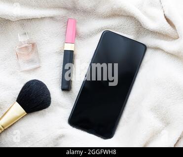 Girly flatlay with mobile phone, lipstick, perfume and make-up brush, smartphone mockup as app template and brand marketing design Stock Photo