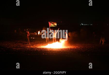 Palestinian Territories, Gaza Strip. August 31st, 2021. Palestinian demonstrators’ burn rubber tires during clashes with the Israeli army dubbed 'Night Confusion' along the border strip separating the Gaza Strip and Israel east of Khan Yunis in the southern Gaza Strip, protesting against the ongoing blockade on the Gaza Strip. Gaza. Stock Photo