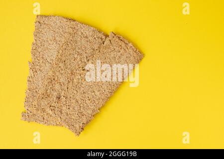 light brown multigrain rye crispbreads isolated on yellow background, bread cracker snacks with empty space for text, top view Stock Photo