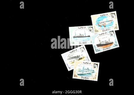 Assorted collection of 1969 postage stamps from Dubai commemorating 60 years of postal service; cancelled Dubaian stamps. Stock Photo