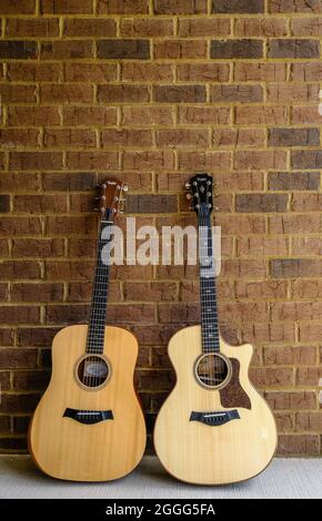 Two Taylor Guitars on Brick Wall Stock Photo