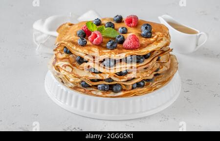 Stack of crepes with fresh raspberries and blueberries Stock Photo