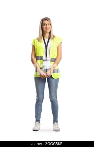 Full length portrait of a female worker in a vest smiling at camera isolated on white background Stock Photo