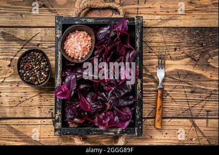 Fresh raw Swiss Ruby or red chard salad Leafs in a wooden tray. wooden background. Top view Stock Photo