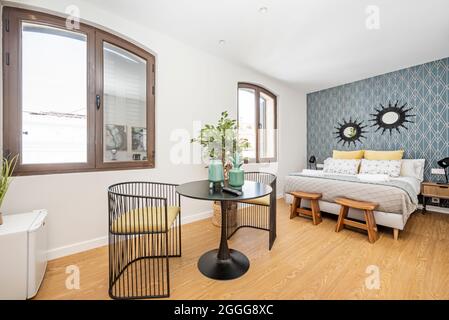 Small studio with king size bed and black multipurpose table in a vacation rental apartment building Stock Photo