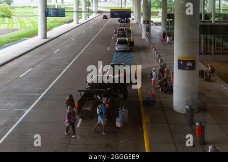 Cars line up to drop off travelers at the terminal entrance at the Indianapolis International Airport in Indy. Stock Photo