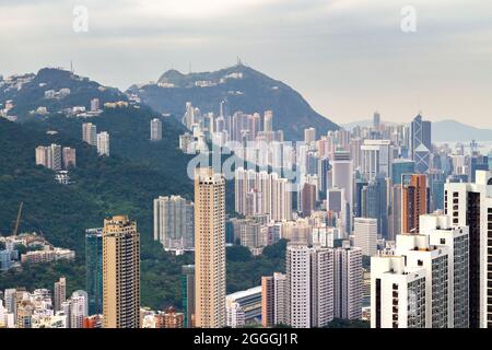 Hong Kong, China - View towards Central district, Victoria Peak and the mountains around from above Happy Valley Stock Photo