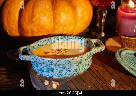 Halloween with candles with pumpkin and cream soup on spooky night - Halloween scene Stock Photo