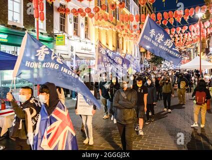 London, UK. 31st Aug, 2021. Pro-democracy protesters wave protest flags while marching through China Town in London during the commemoration of the Prince Edward incident, where police stormed inside Prince Edward MTR station in Hong Kong to make arrests against massive anti-government protests two years ago. Credit: SOPA Images Limited/Alamy Live News Stock Photo