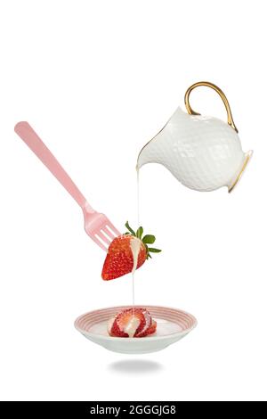 Levitating jug pouring sweetened condensed milk on fresh strawberry. Levitation food concept. Stock Photo