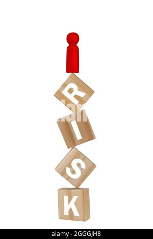 A bright red wood peg man model standing on a balancing stack of wood blocks labelled with letter risk. Levitation photography concept. Stock Photo
