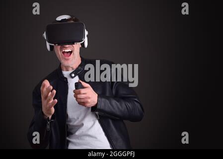 Man having fun dressed casual playing with virtual reality glasses with black isolated background Stock Photo