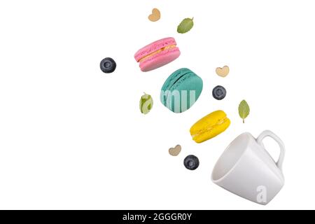 Colorful macaroons  levitating on white background with blueberries and mint leaves. Stock Photo