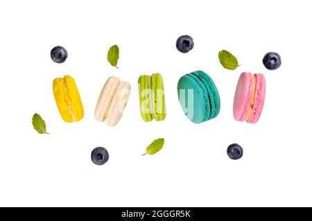 Colorful macaroons  levitating on white background with blueberries and mint leaves. Stock Photo