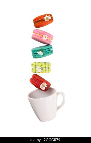 Colorful macaroons levitating on a white tea cup. Isolation on white background. Stock Photo