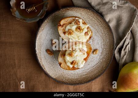 Close up of appetizing sweet grilled pears with walnuts and honey. Autumn rustic dessert Stock Photo