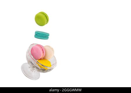Levitating colorful macaroons on a falling glass ice cream cup. Levitation food photography concept. Stock Photo