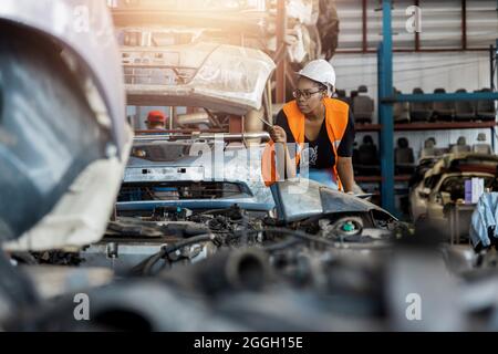 Portrait of Black African American woman holding tablet check and work in factory of old auto spare parts Stock Photo