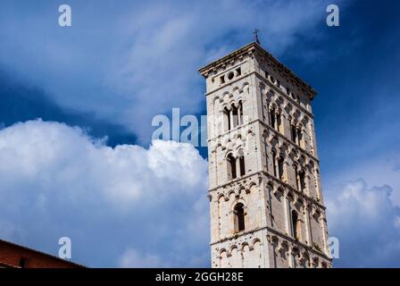 Saint Micheal in Foro Church medieval bell tower among clouds. Romanesque belfry erected in the 13th century in the city of Lucca, Tuscany Stock Photo