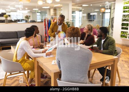 Diverse male and female colleagues working together, discussing in casual meeting Stock Photo