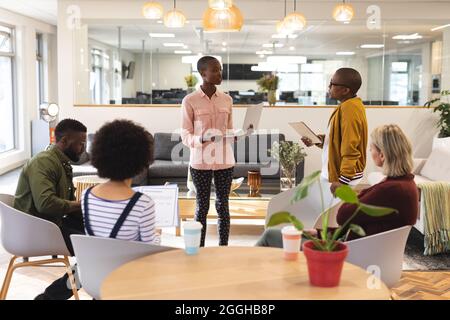 Diverse male and female colleagues working together, discussing in casual meeting Stock Photo