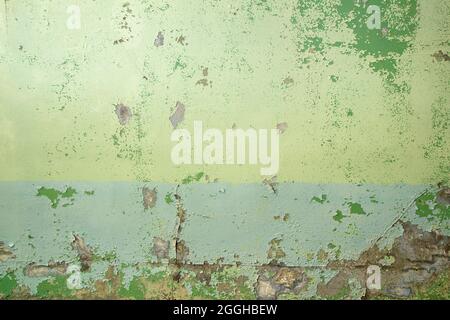 Old weathered concrete wall with green peeling paint, grunge background or texture Stock Photo