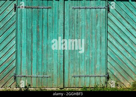Turquoise painted old rustic barn door Stock Photo